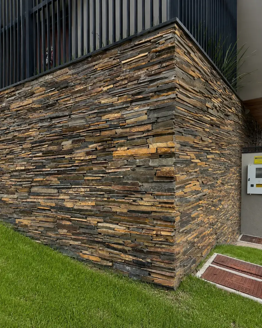 Parede externa contemporânea revestida com filetes de Pedra Ferro