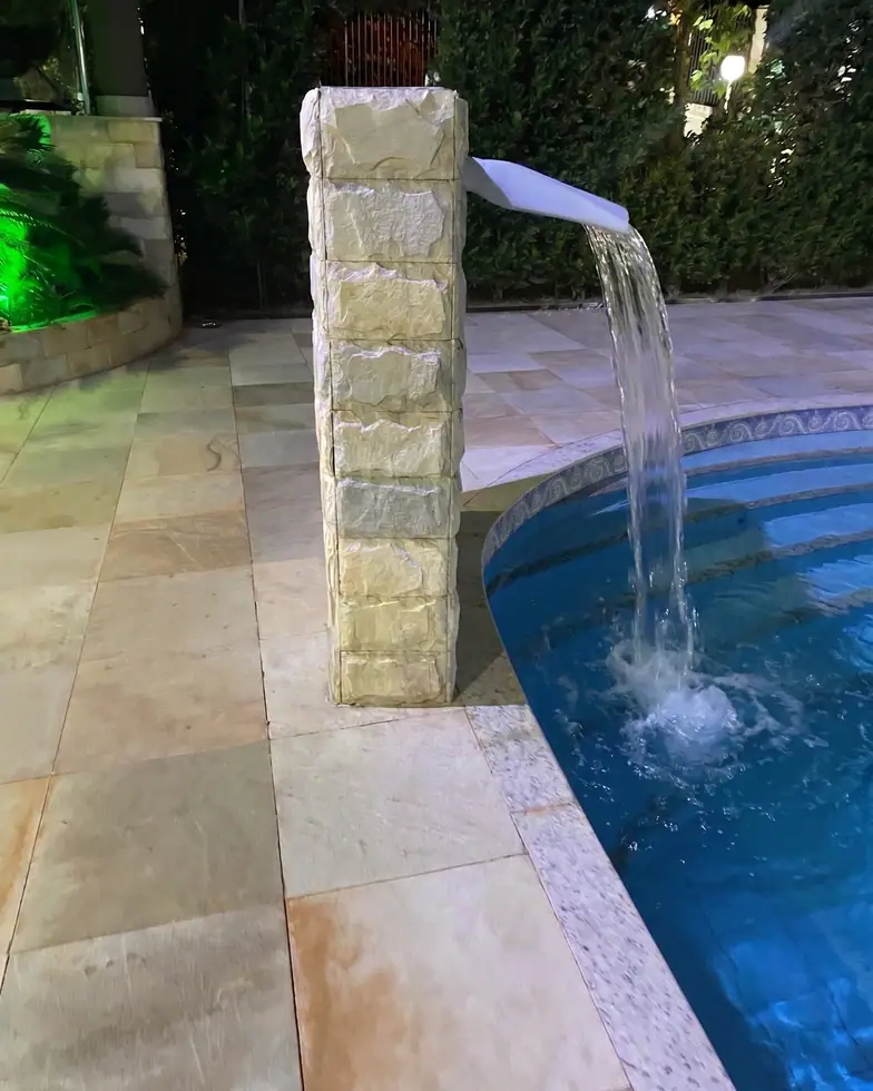 Piscina com cascata e piso quadrado de Pedra São Tomé Amarela