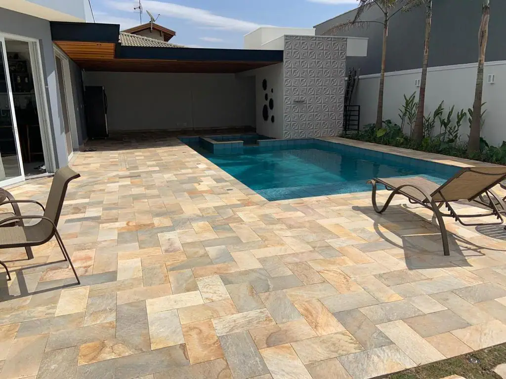 Área de piscina revestida com Pedra São Tomé Amarela em paginação retangular