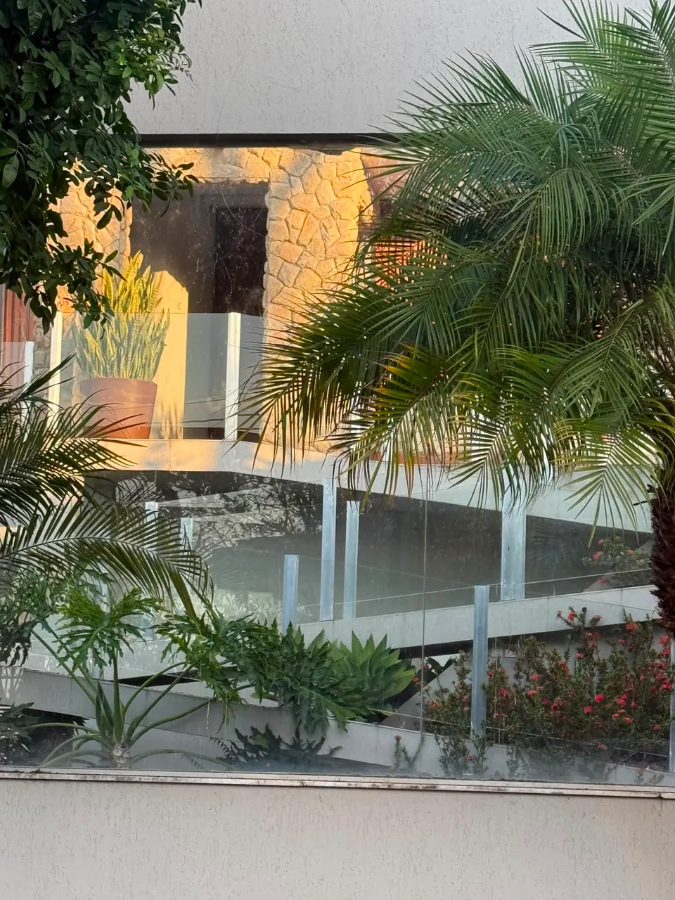 Fachada residencial com revestimento de Moledo Champagne e paisagismo