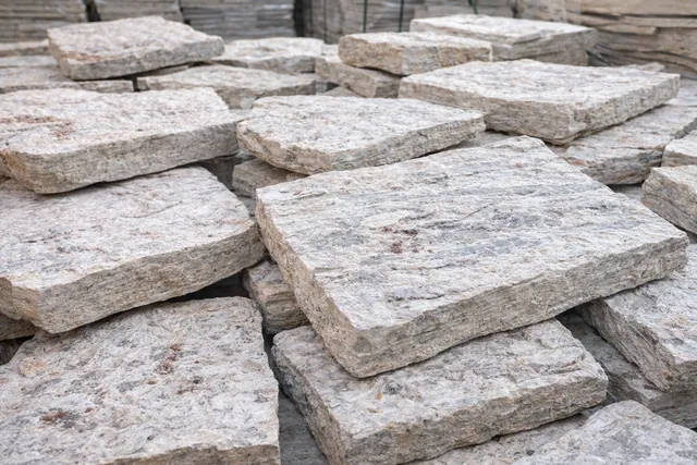 Pedra Miracema branca Bossa Nova em blocos irregulares com textura natural e leve presença de pintas rosadas