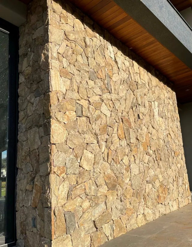 Revestimento em pedra miracema madeira irregular aplicado em parede externa com acabamento natural rústico