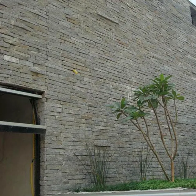 Parede externa com filetão de pedra Miracema verde em revestimento natural